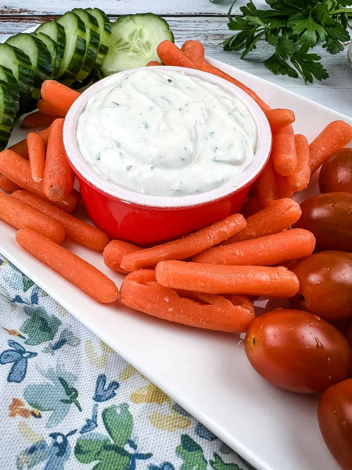 garlic dip in a red bowl with baby carrots