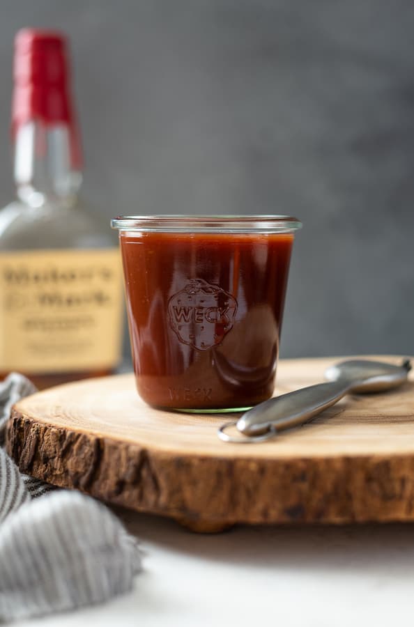 jar of bourbon bbq sauce on a wood plank