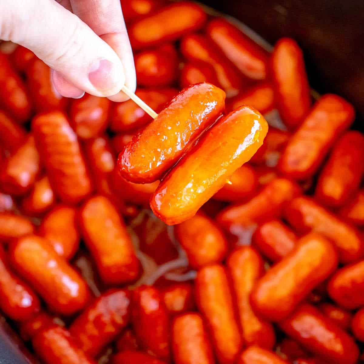 hand holding toothpick with bbq little smokies