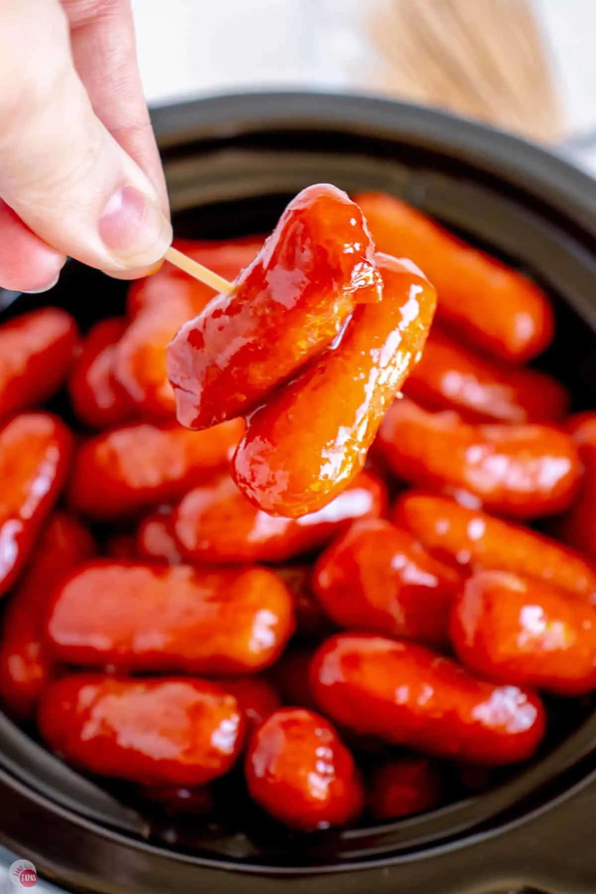 hand holding two little smokies on a toothpick