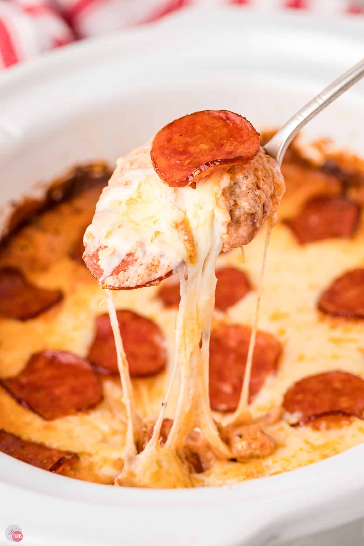 spoon scooping pizza dip out of crockpot