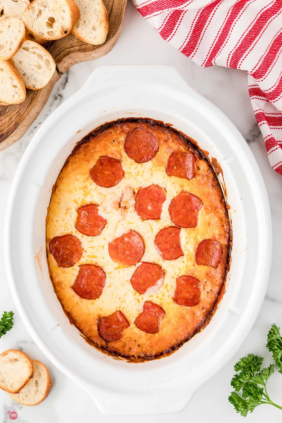 cooked crockpot pizza dip in a white slow cooker