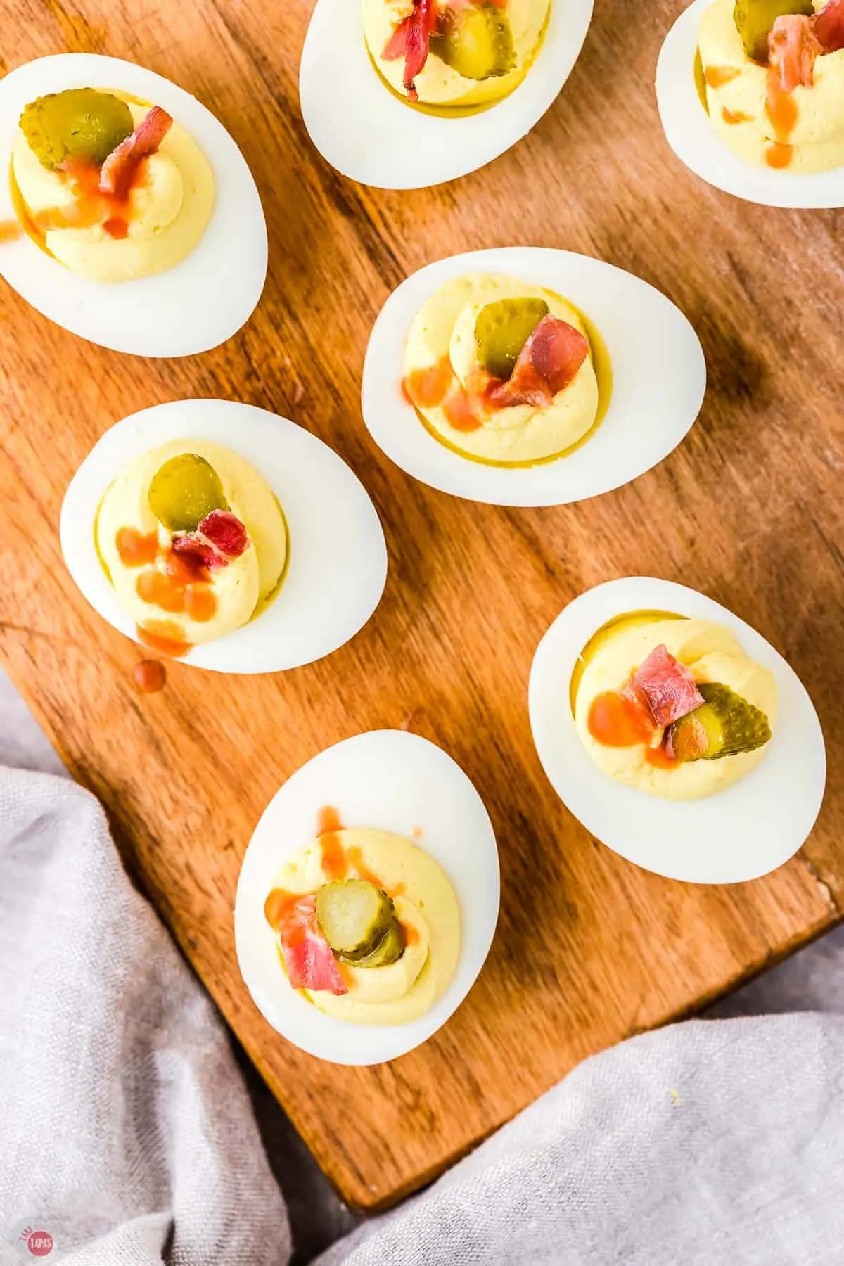 tray of deviled eggs with pickles on top