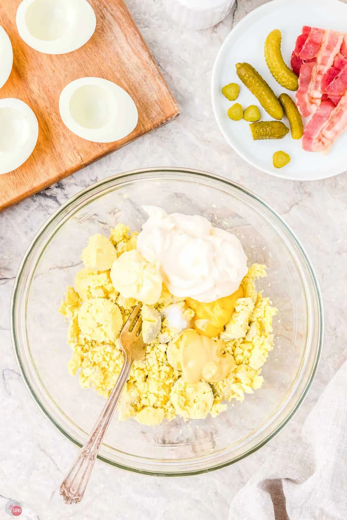 cooked egg yolks and mayo in a bowl with a fork