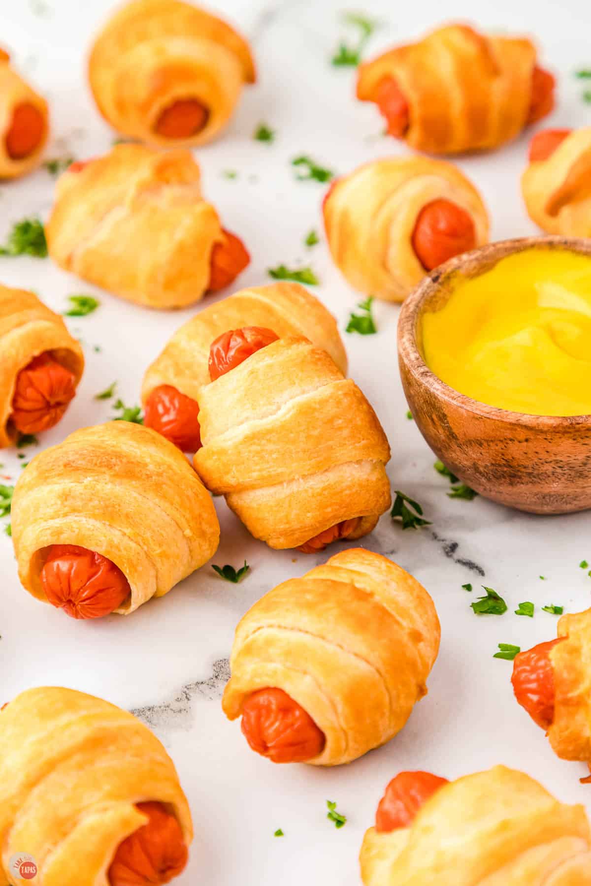 wrapped smokies next to a bowl of mustard