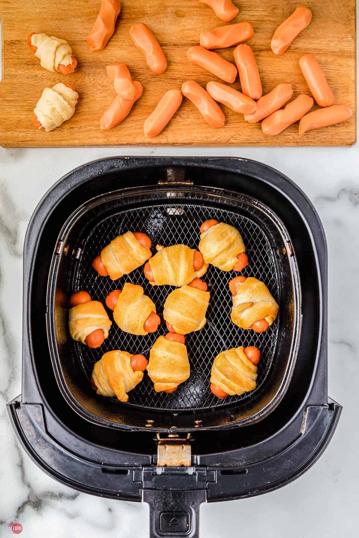 air fry dough wrapped sausages in a black basket