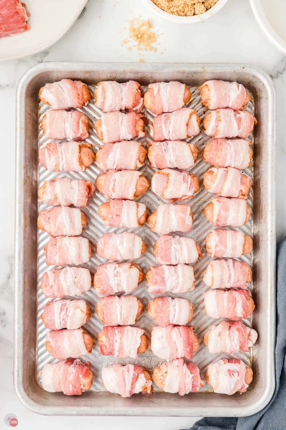 unbaked sausages on a metal cookie sheet