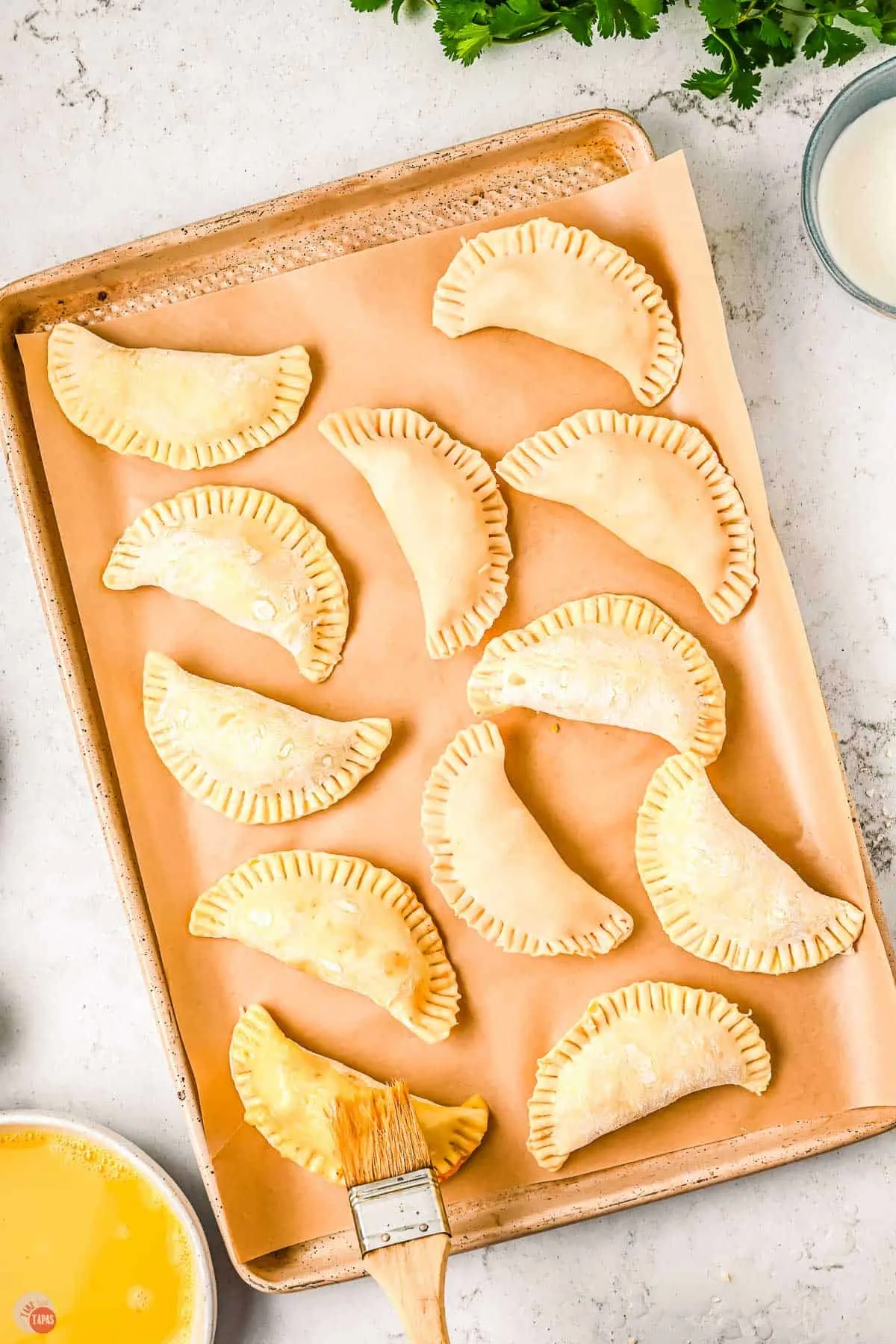 unbaked empanadas on a baking sheet