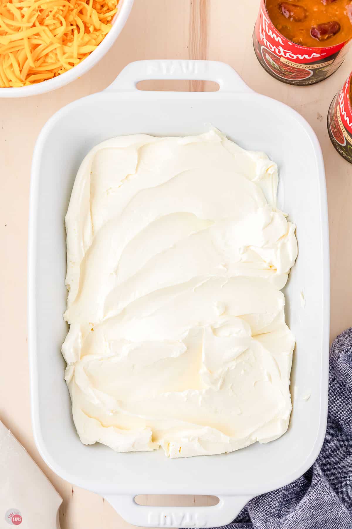 cream cheese spread in the bottom of a white casserole dish