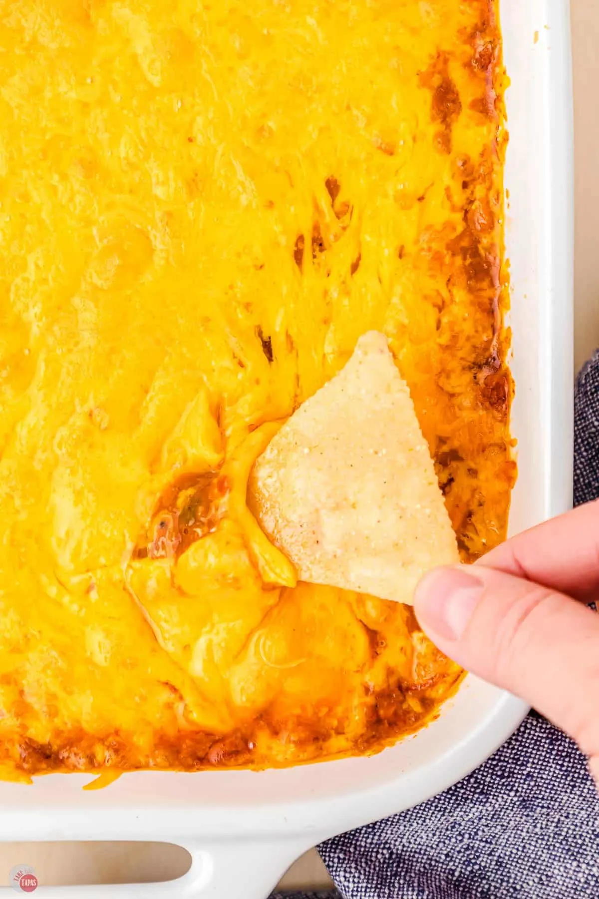 chip dipping into chili cheese dip