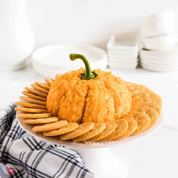pumpkin cheese ball on a platter with crackers