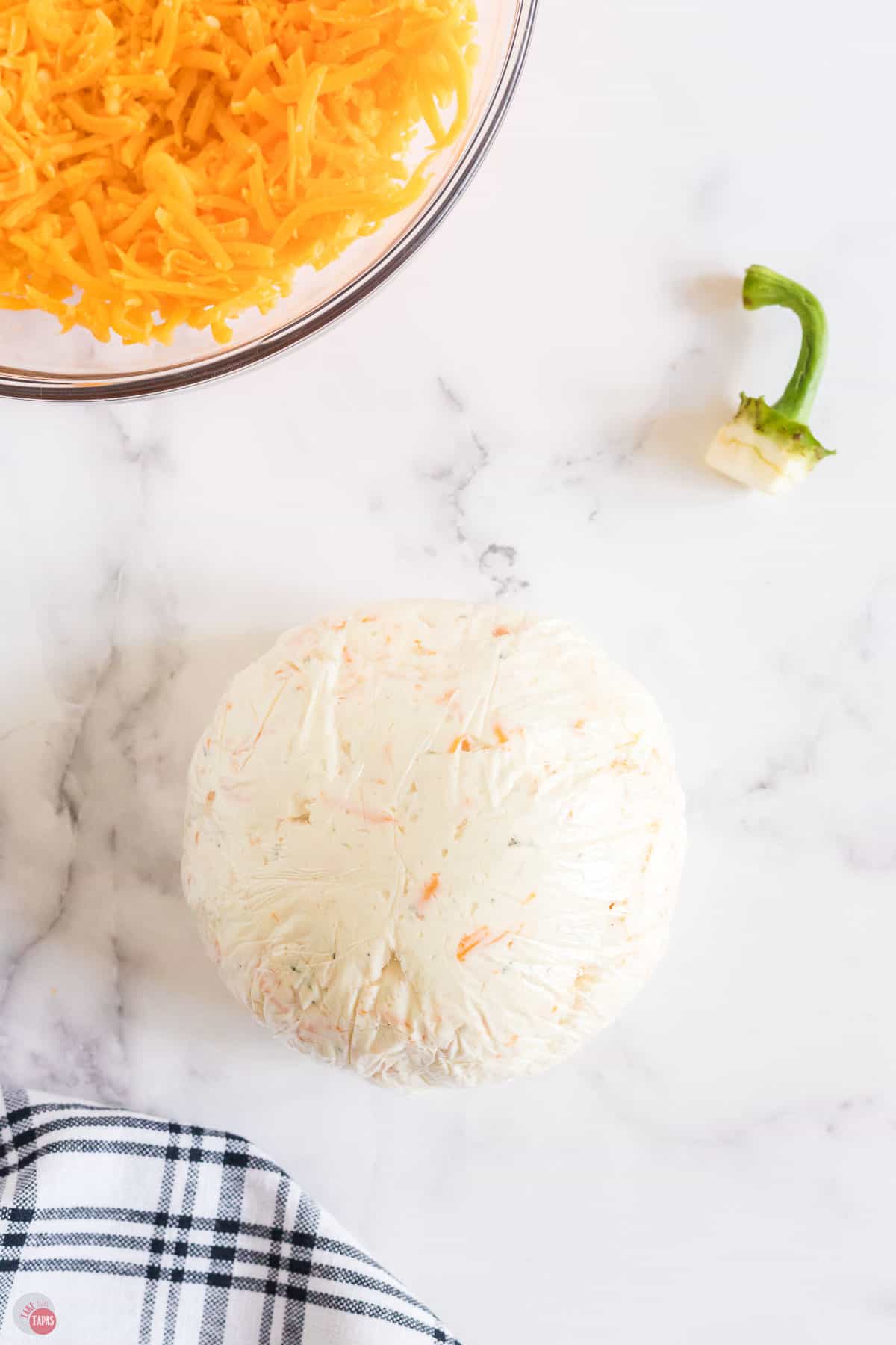 pumpkin cheese ball wrapped in plastic