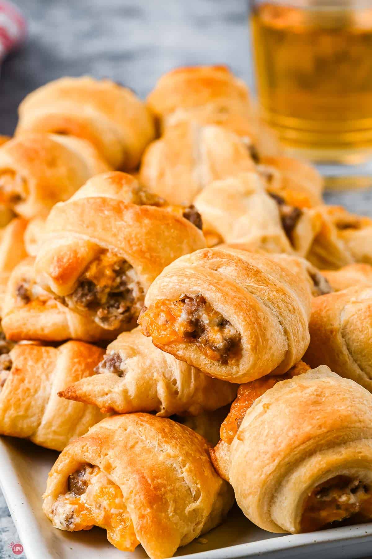 close up of cream cheese sausage crescents on a white tray