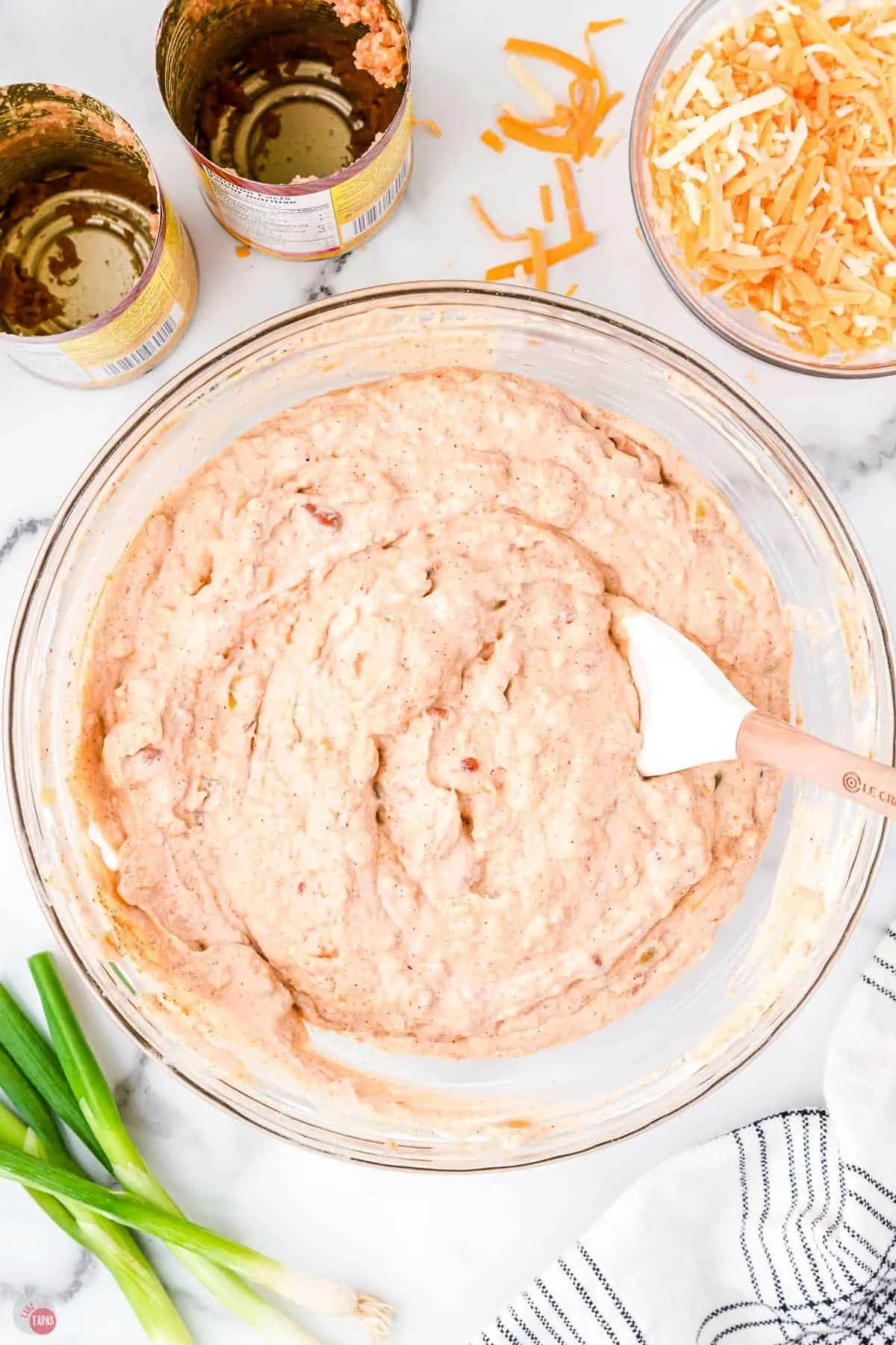 mixed dip ingredients in a clear bowl with a white spatula