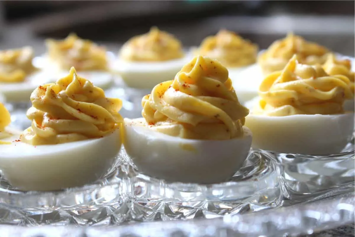 close up of three filled eggs on a clear platter
