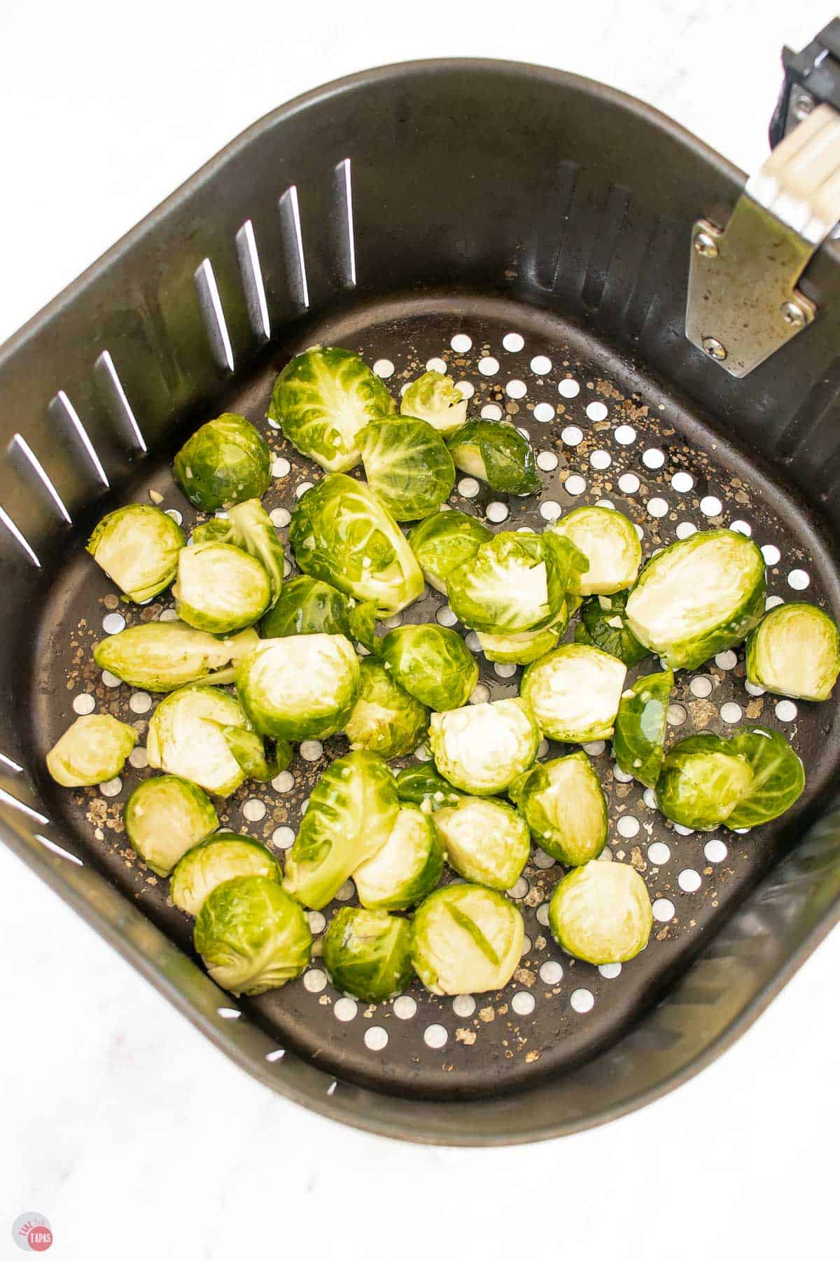 uncooked sprouts in an air fryer basket