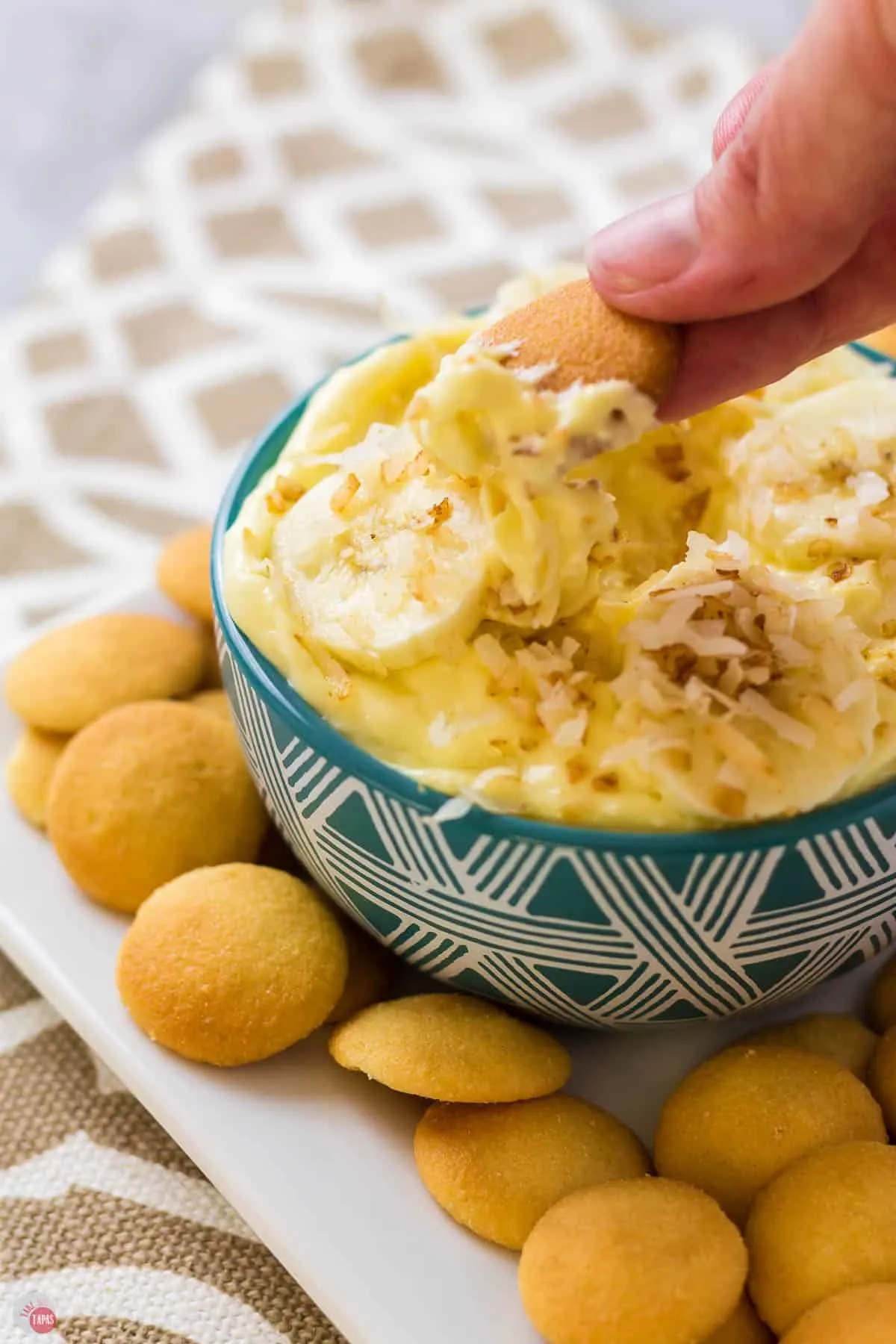 hand dipping wafer in banana dip