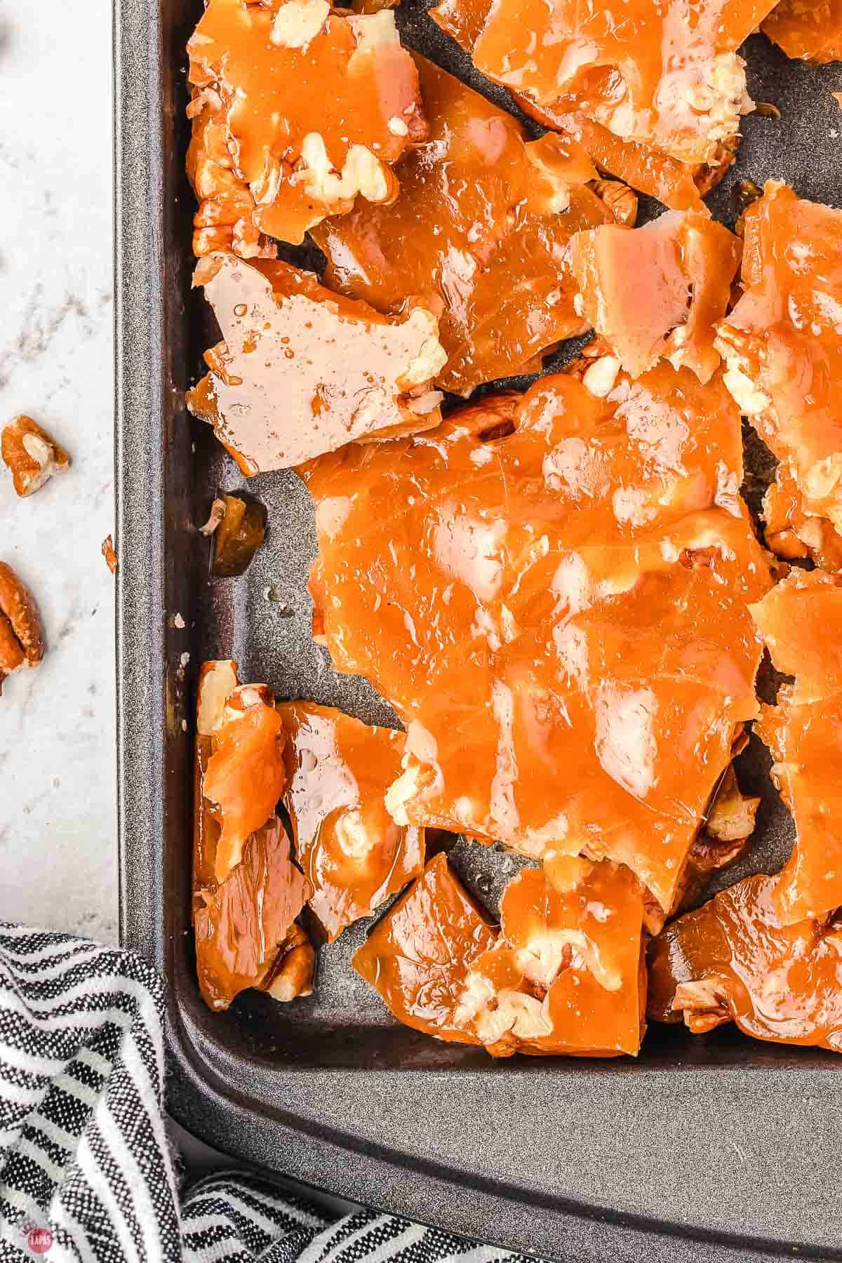 broken pieces of toffee on a baking sheet