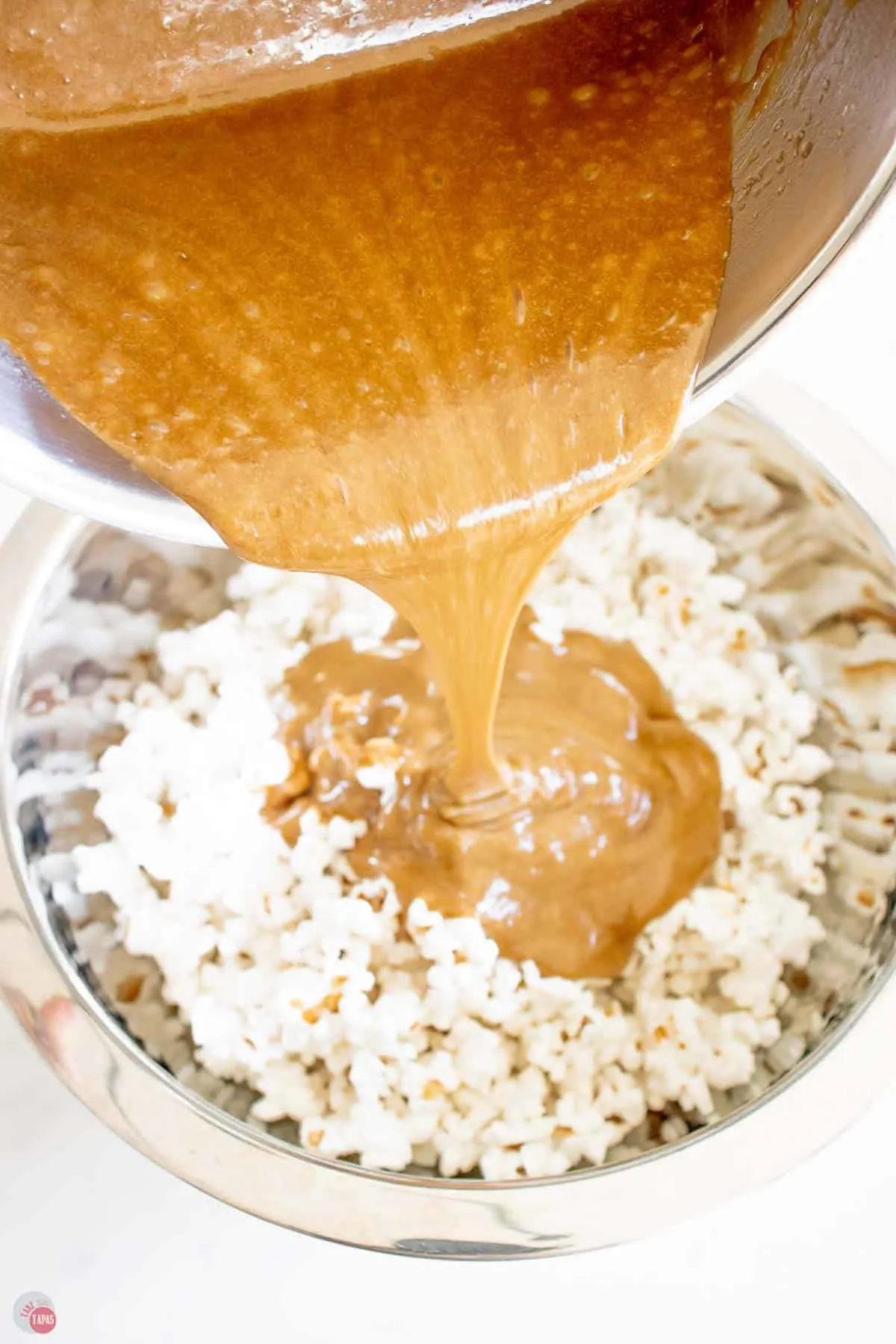 pouring caramel over popcorn