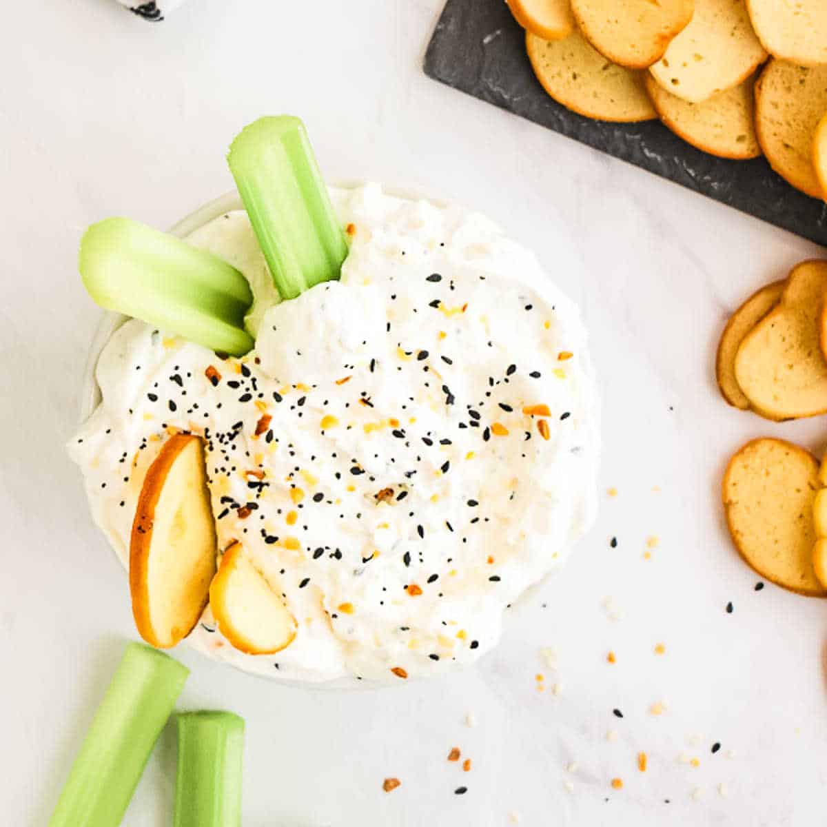 bowl of everything bagel dip with chips and celery sticks
