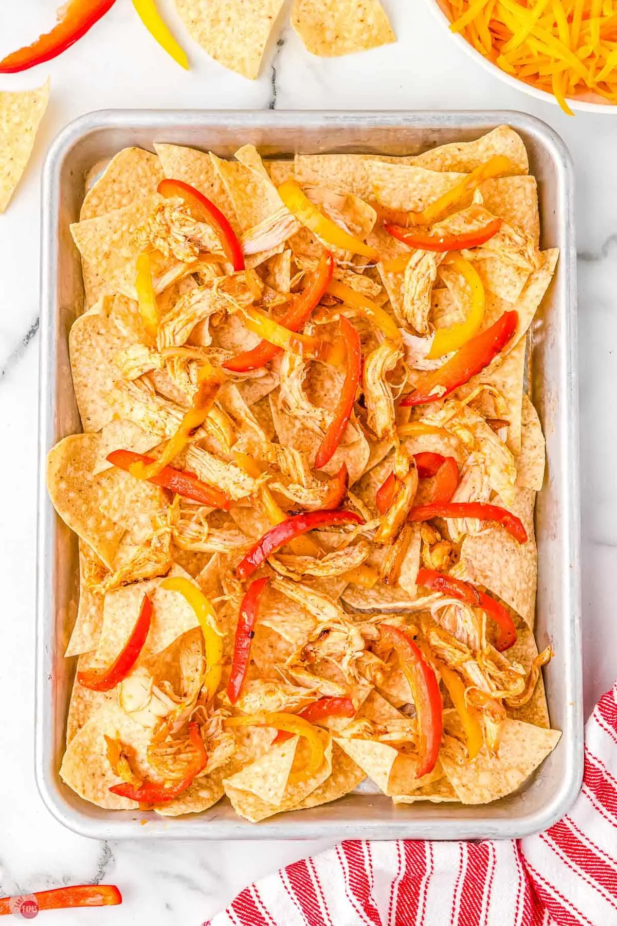 tortilla chips and chicken on a sheet pan