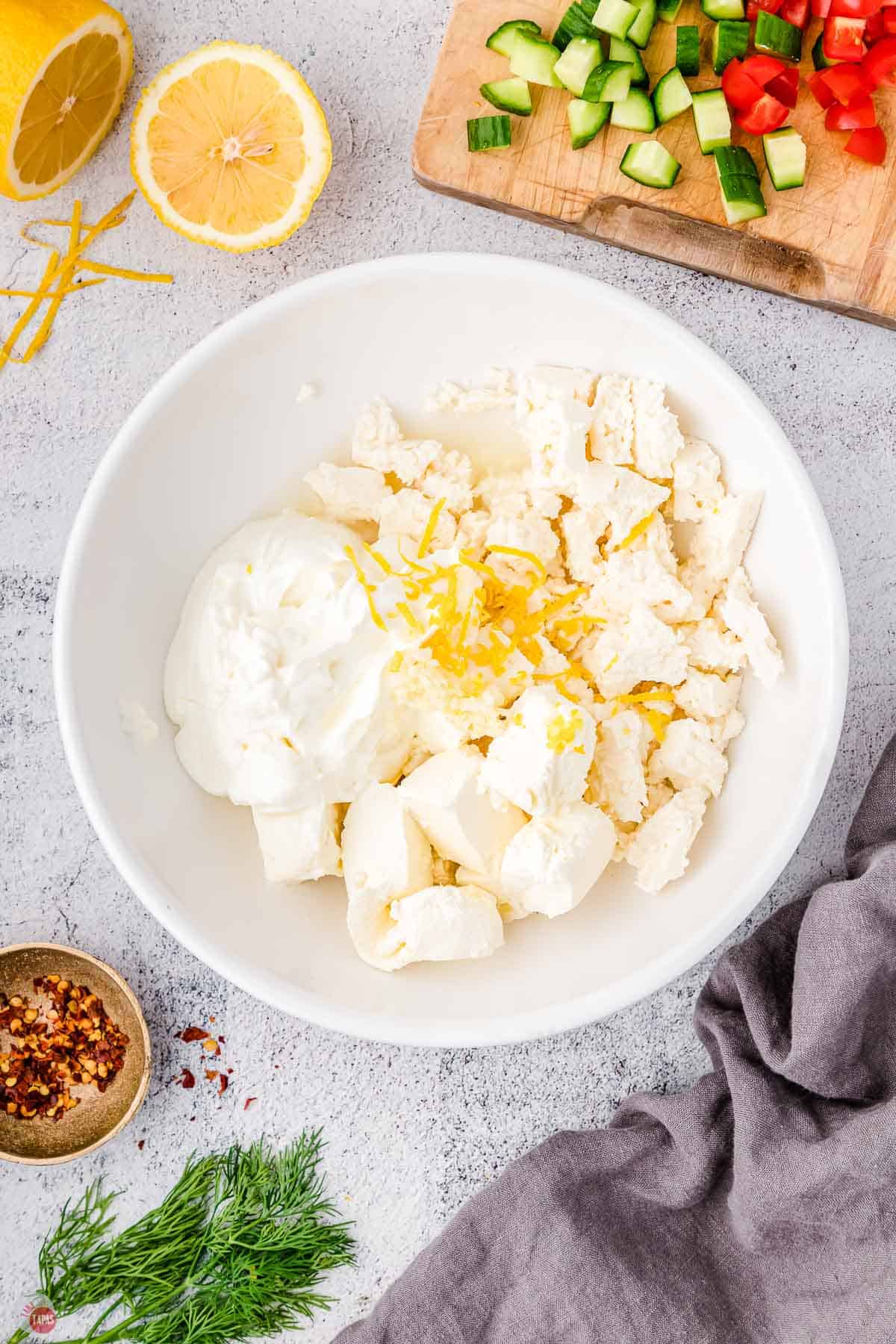 cream cheese and feta in a bowl with lemon zest