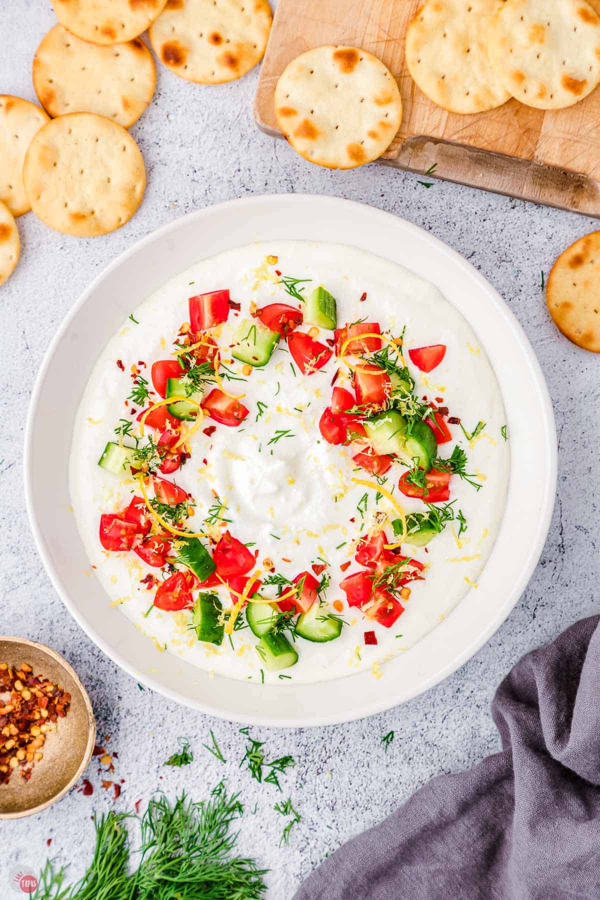 overhead picture of Greek feta dip with bagel chips and a blue napkin