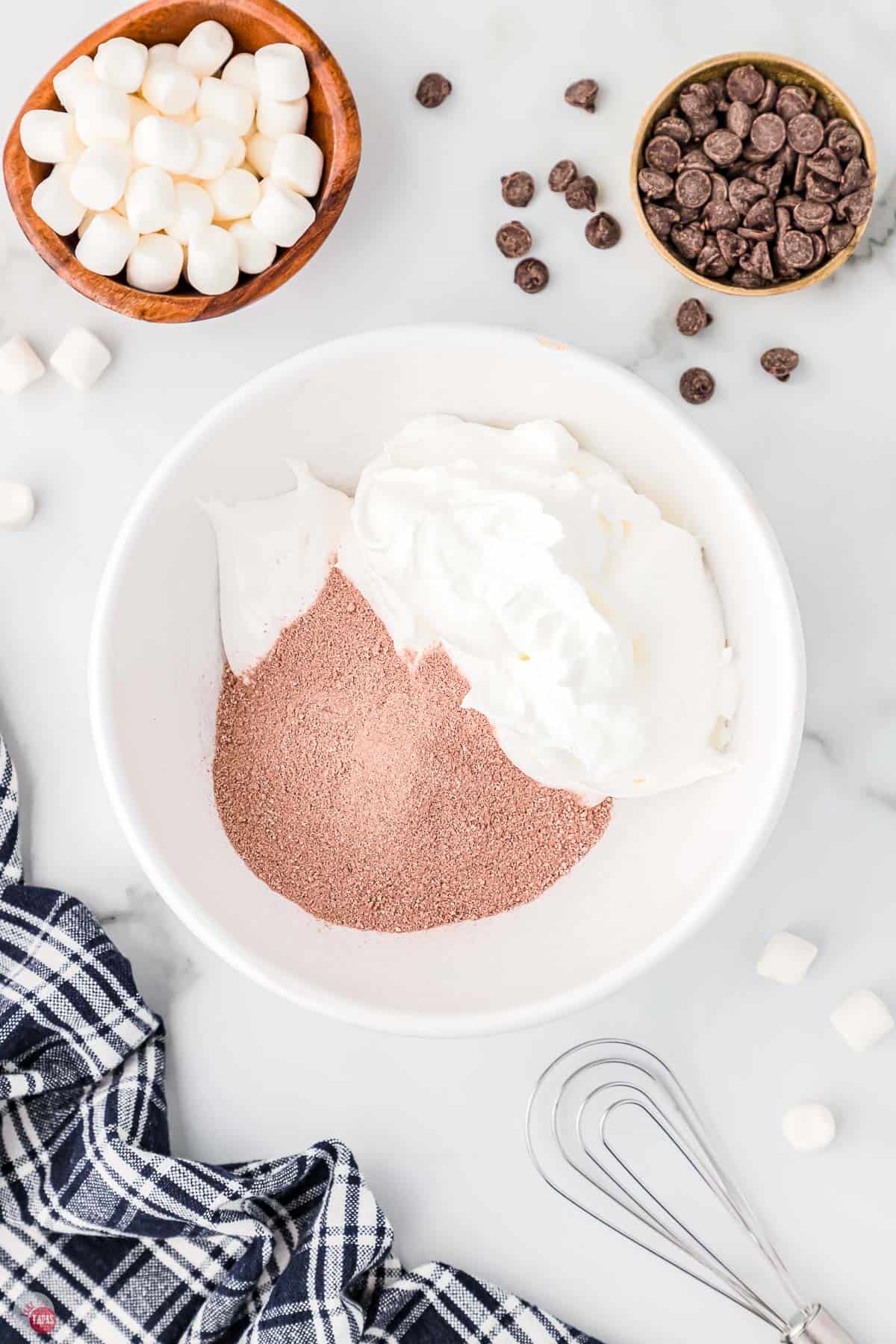 cocoa powder and whipped topping in a bowl with a whisk