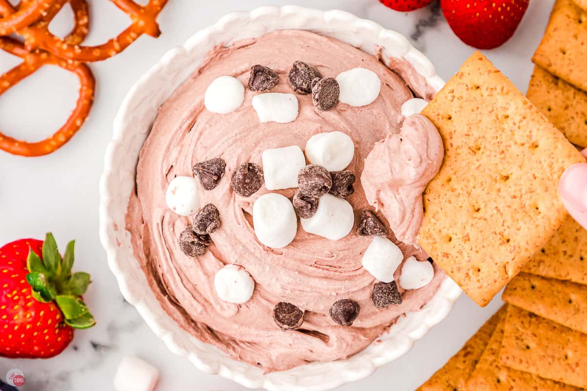 bowl of dip with graham cracker dipping in it