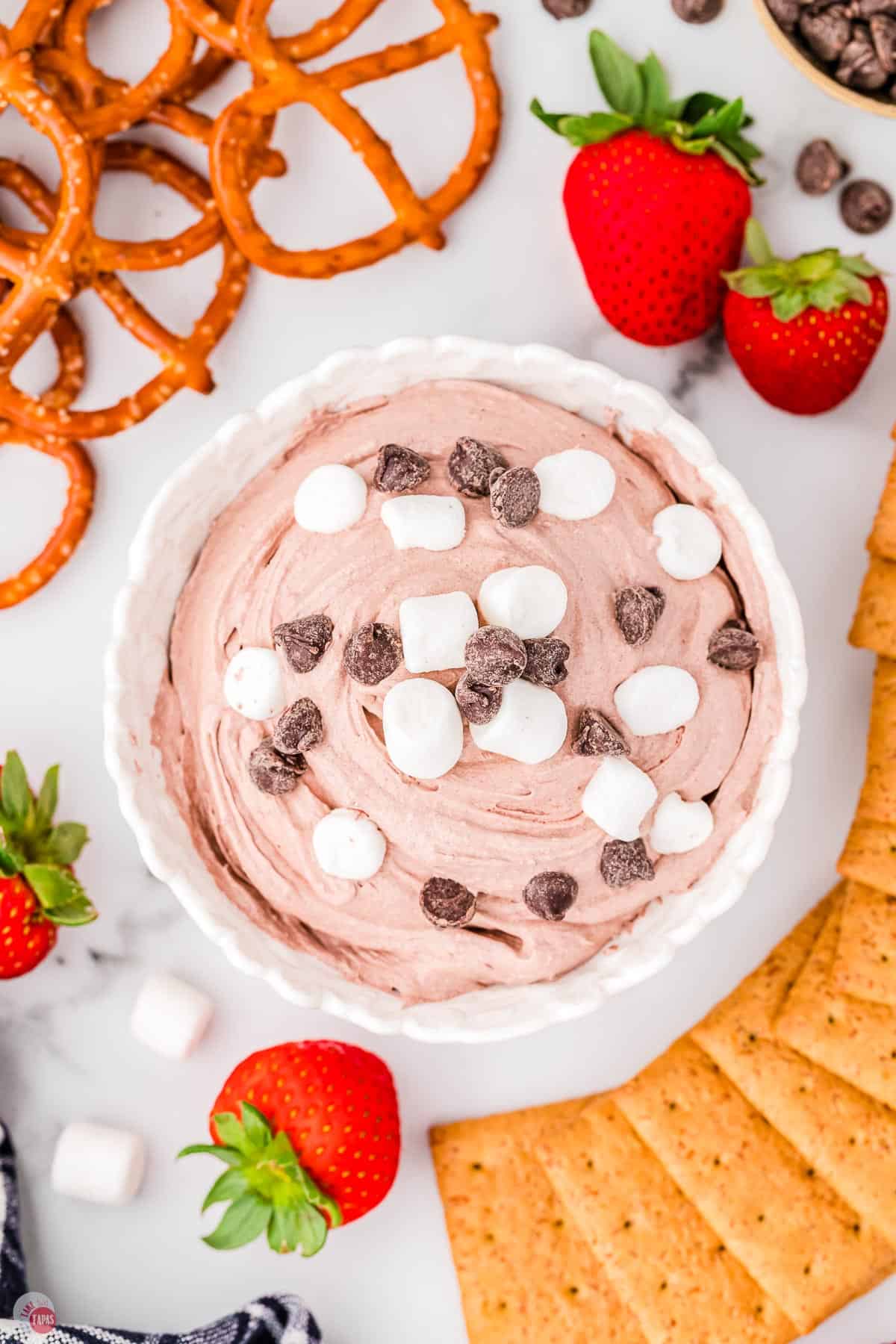 overhead picture of bowl of hot cocoa dip surrounded by strawberries