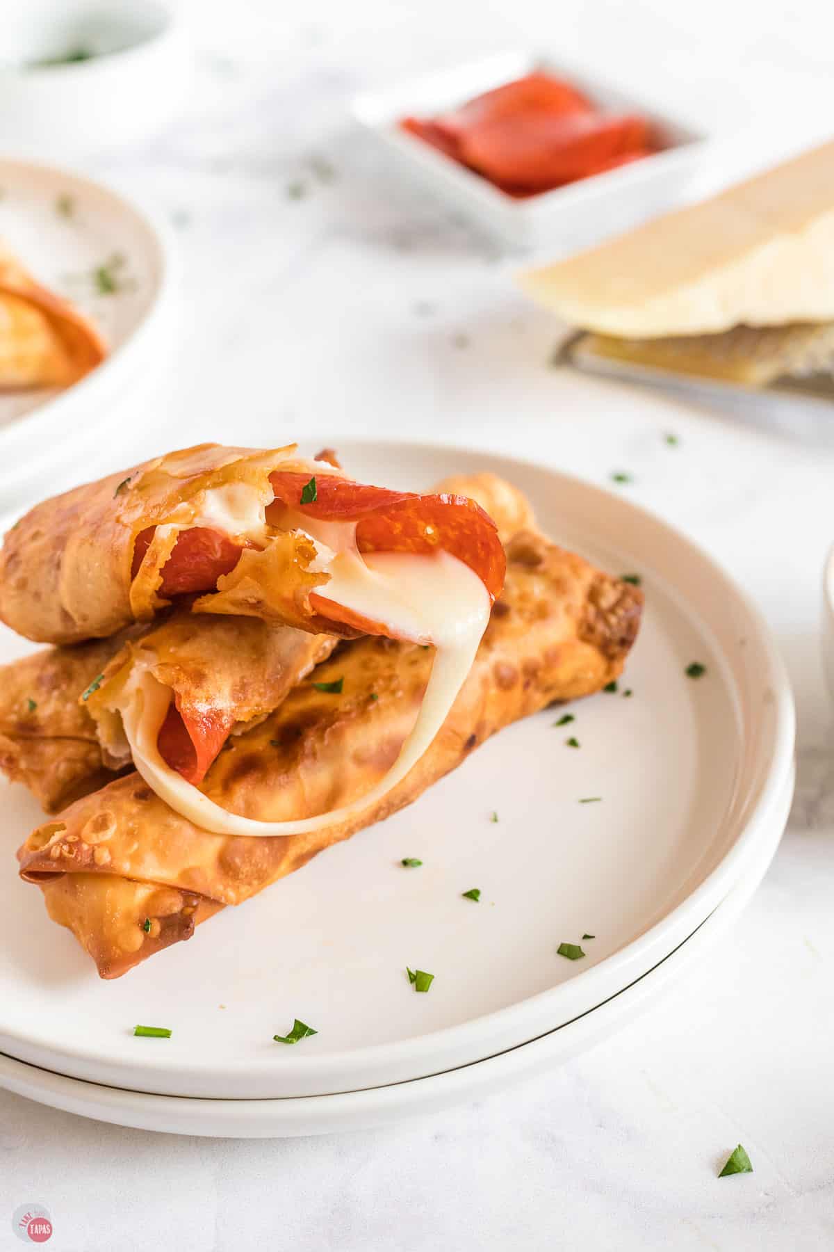 plate of pizza egg rolls broken open and cheese melting out