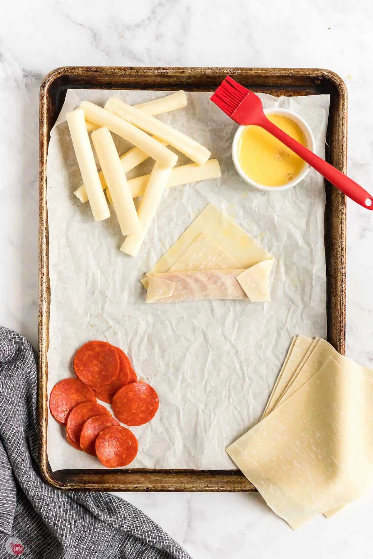 egg roll being rolled up on baking sheet