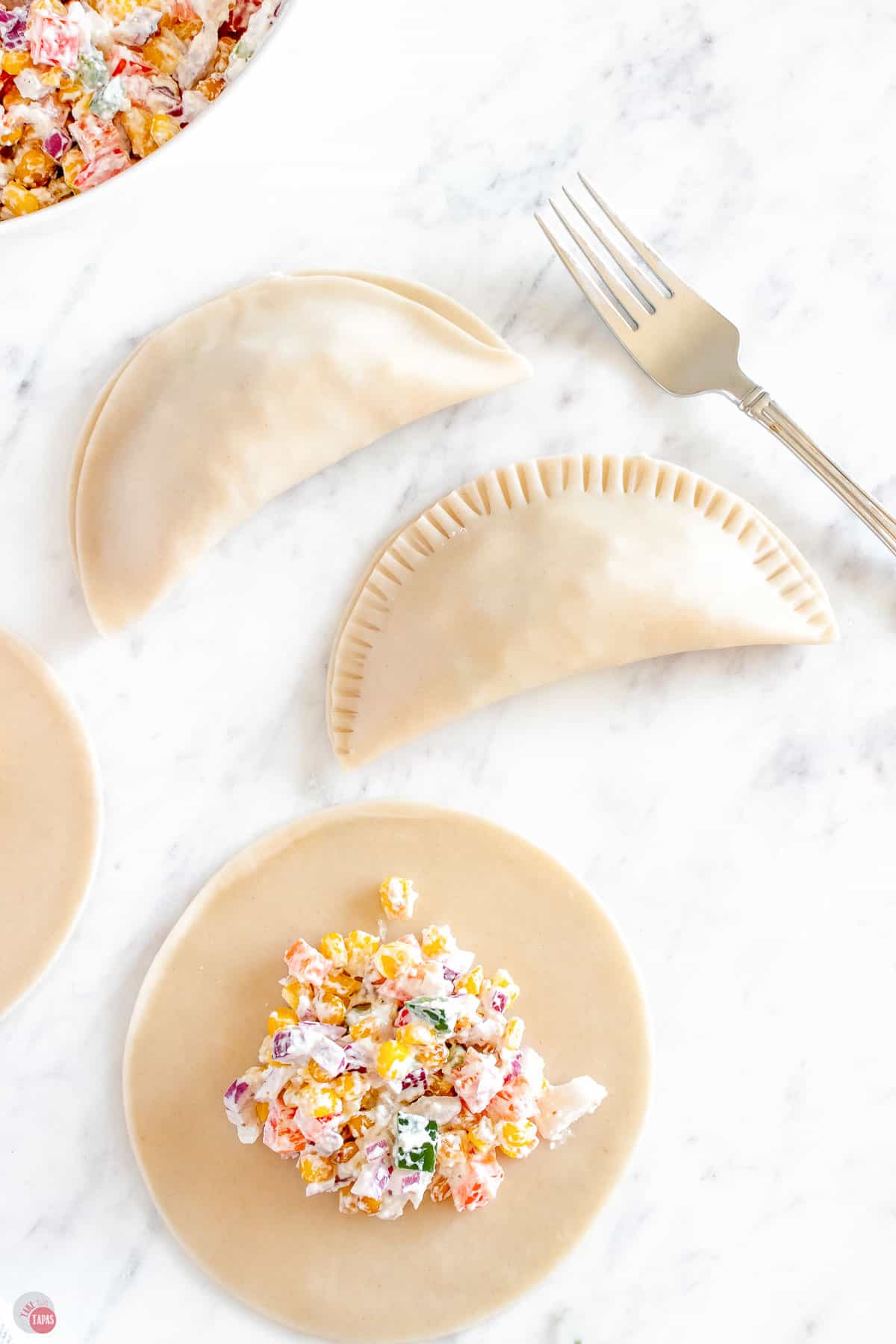 close up of fork crimping dough edge