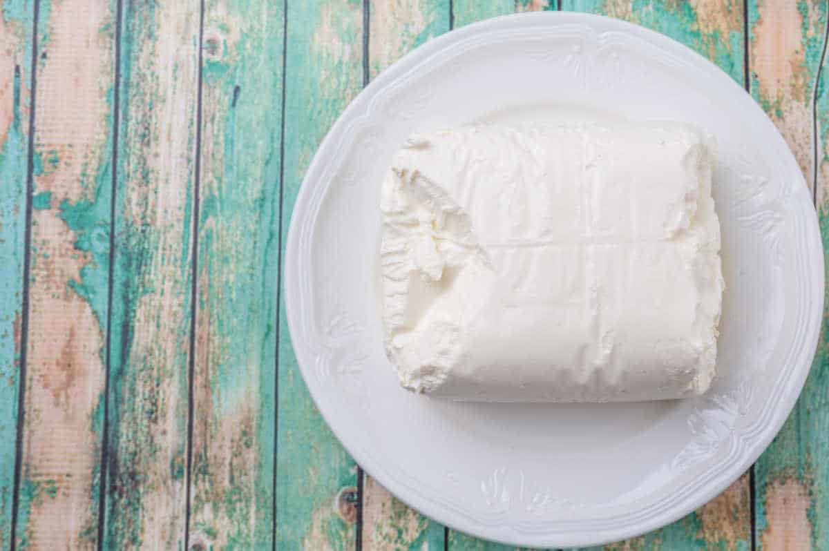 block of cream cheese on green board