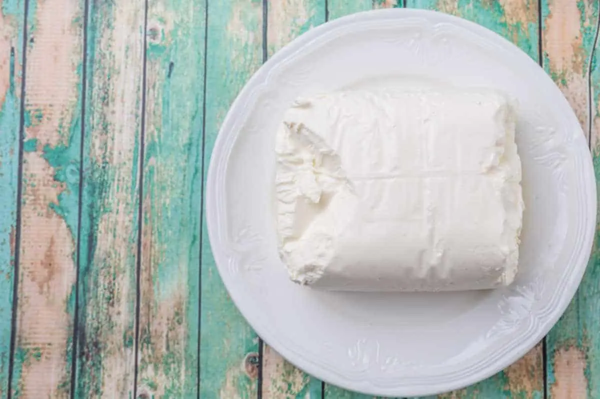 block of cream cheese on green board