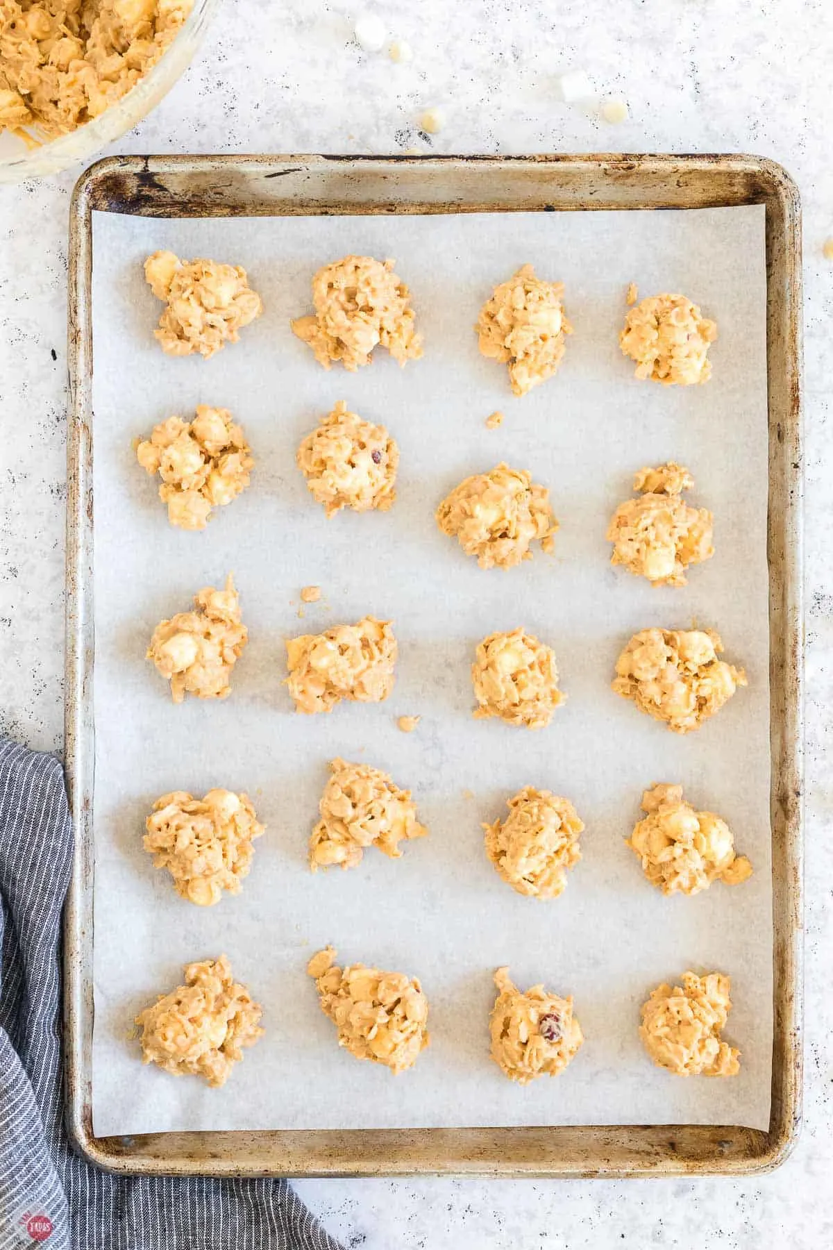 scoops of cookie dough on a baking sheet with parchment paper