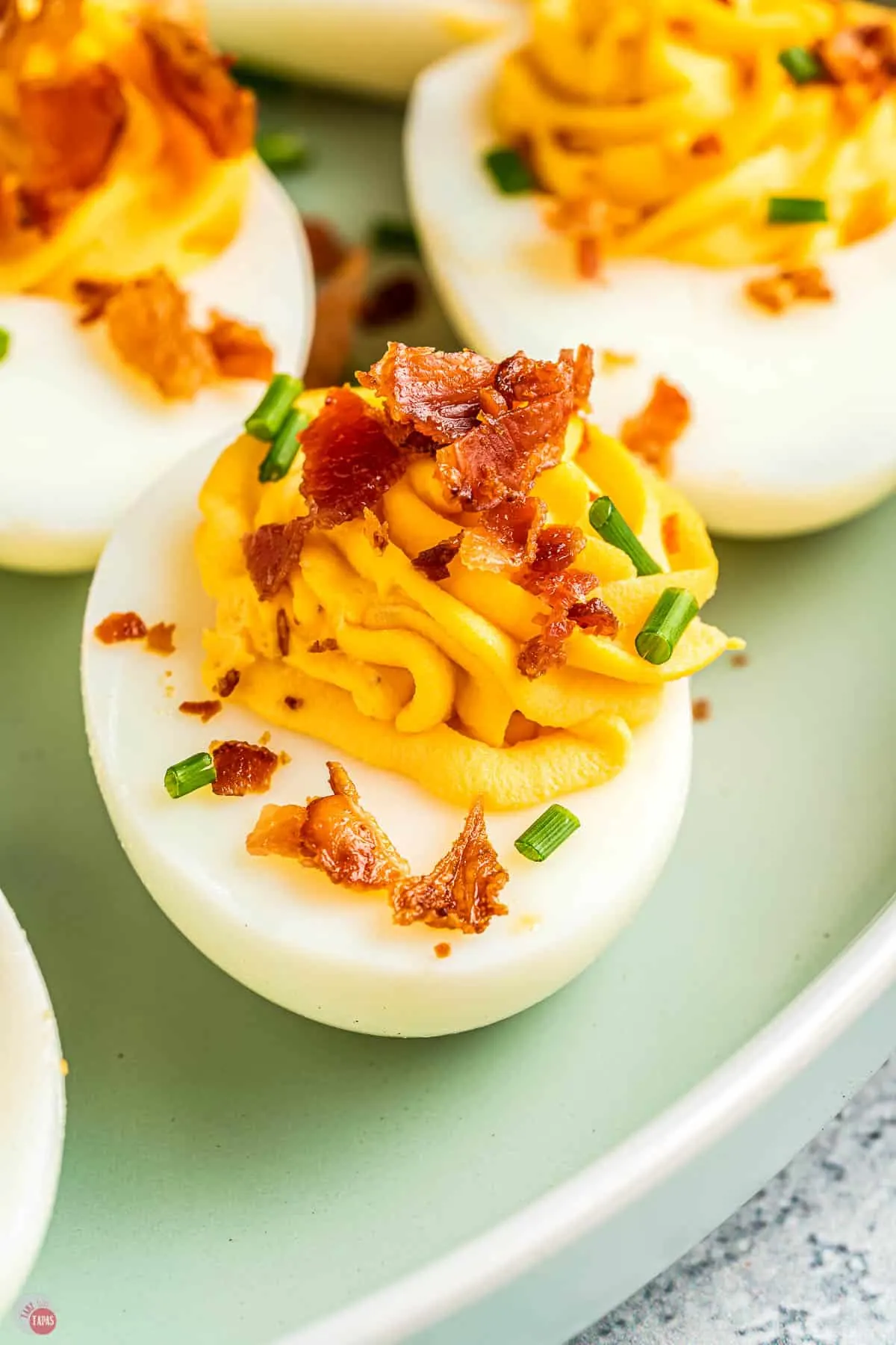 close up of deviled egg with crispy bacon