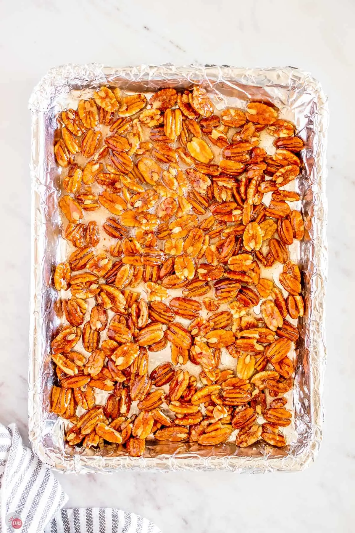 glazed pecans on a foil-lined baking sheet