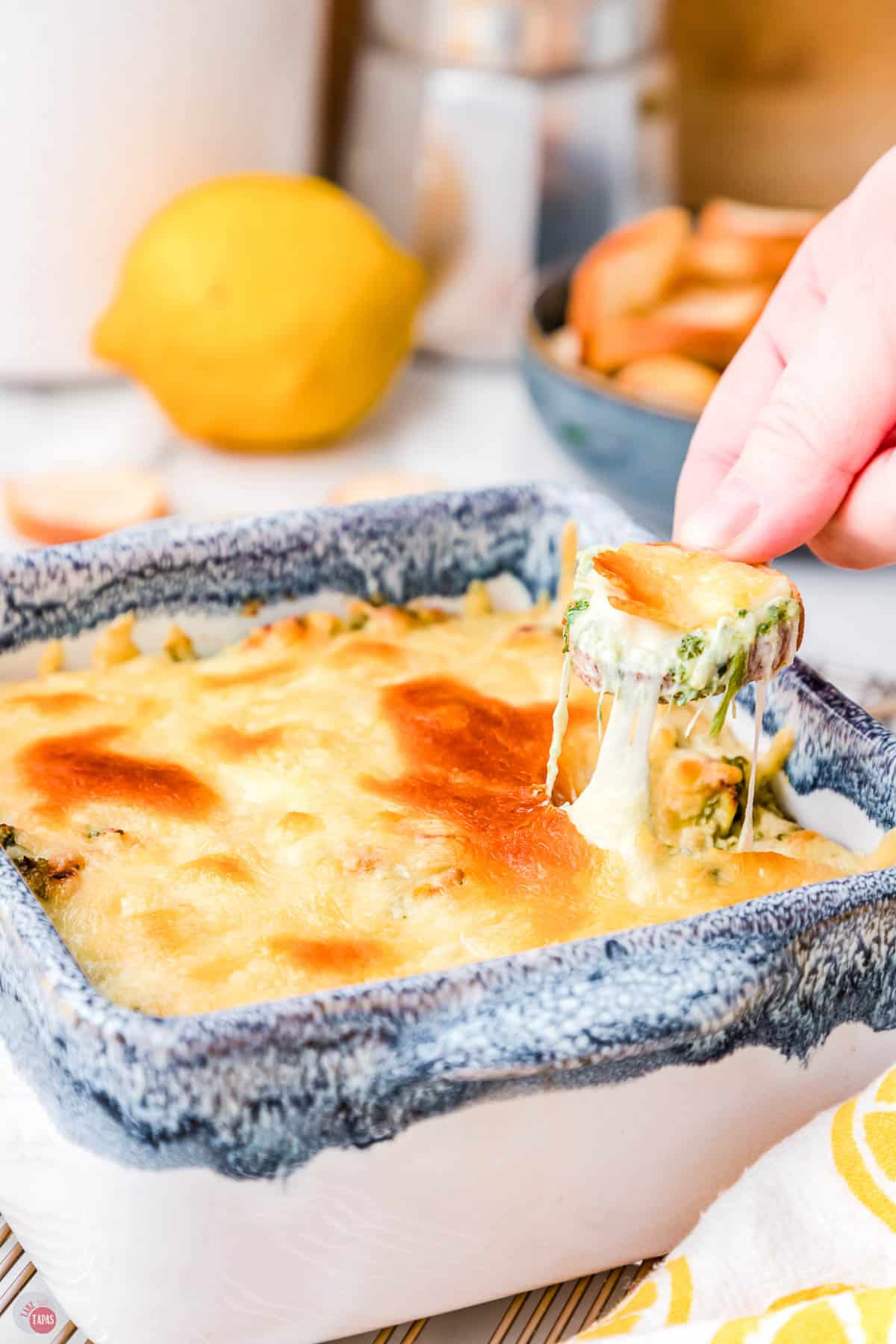 crostini pulling cheese out of a bowl