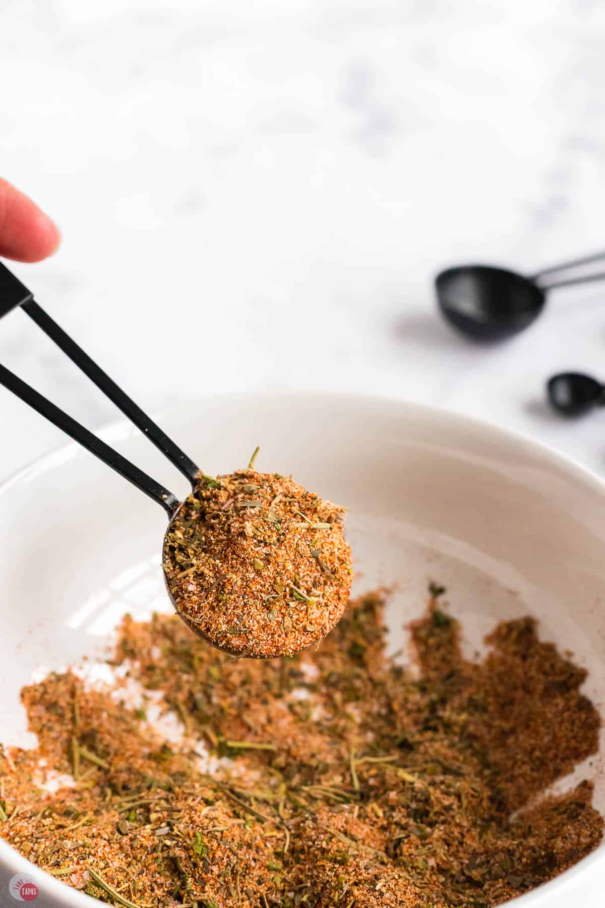 scoop of seasoning above a small bowl