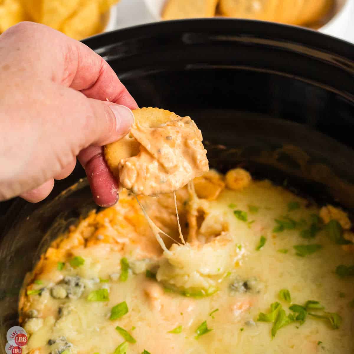 cracker of dip in a black pot