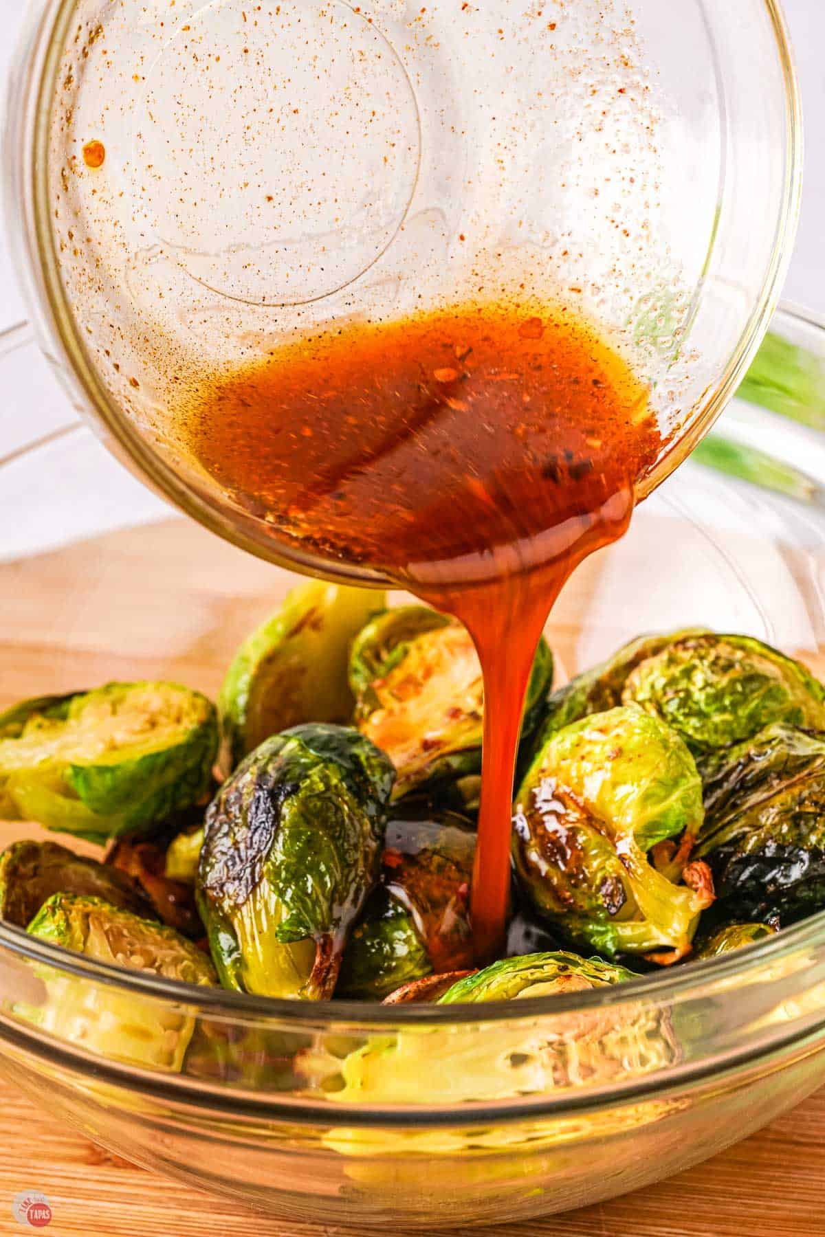 sauce pouring over roasted brussel sprouts