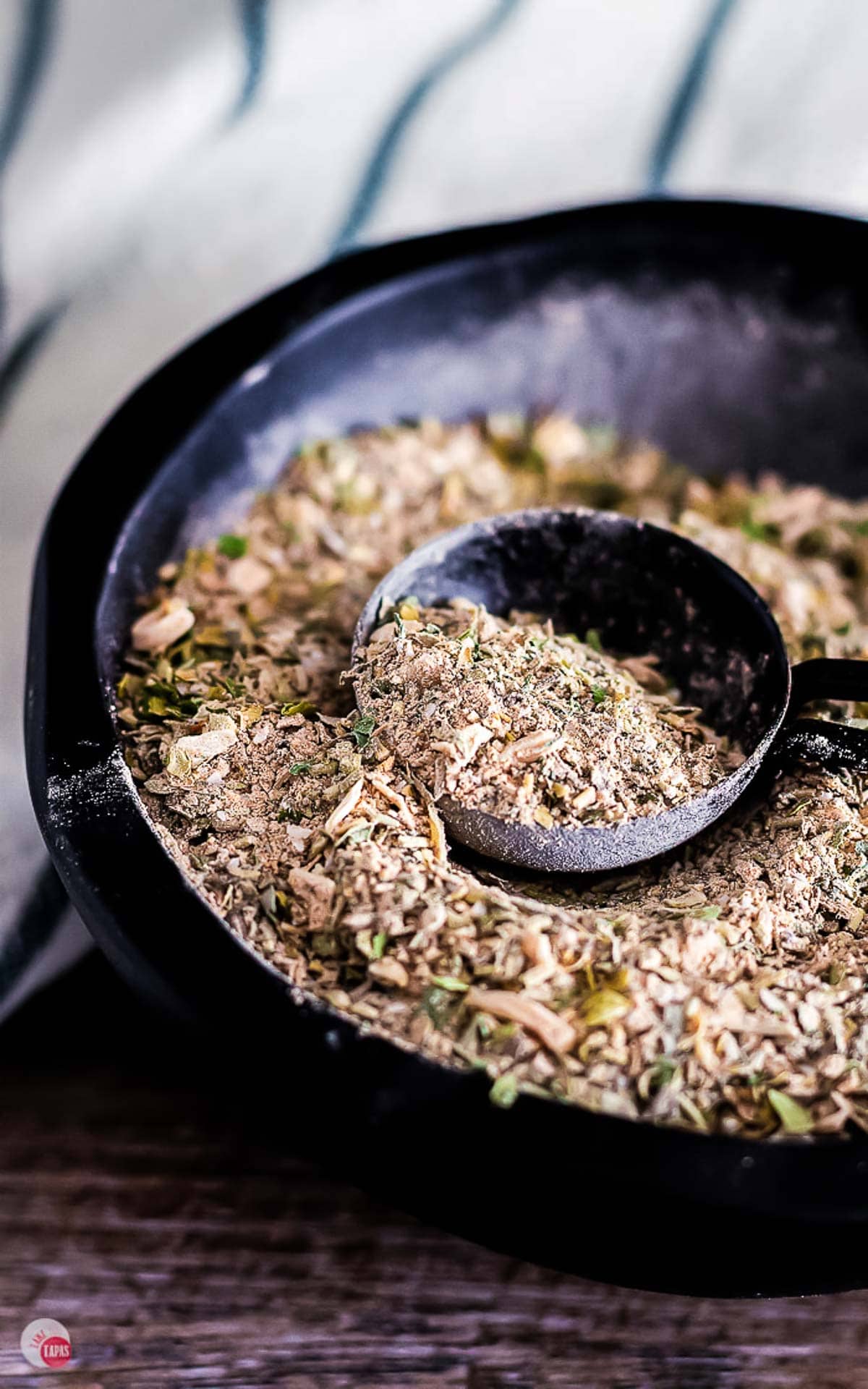 bowl of Greek seasoning with black spoon