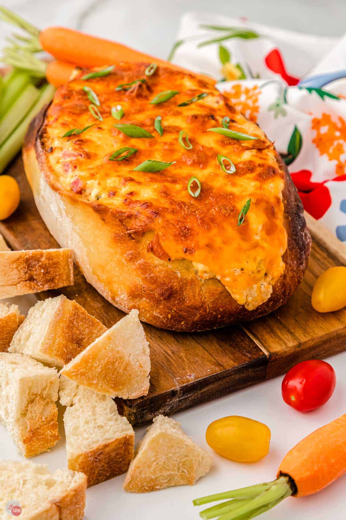 side view of bread bowl filled with dip and melted cheese