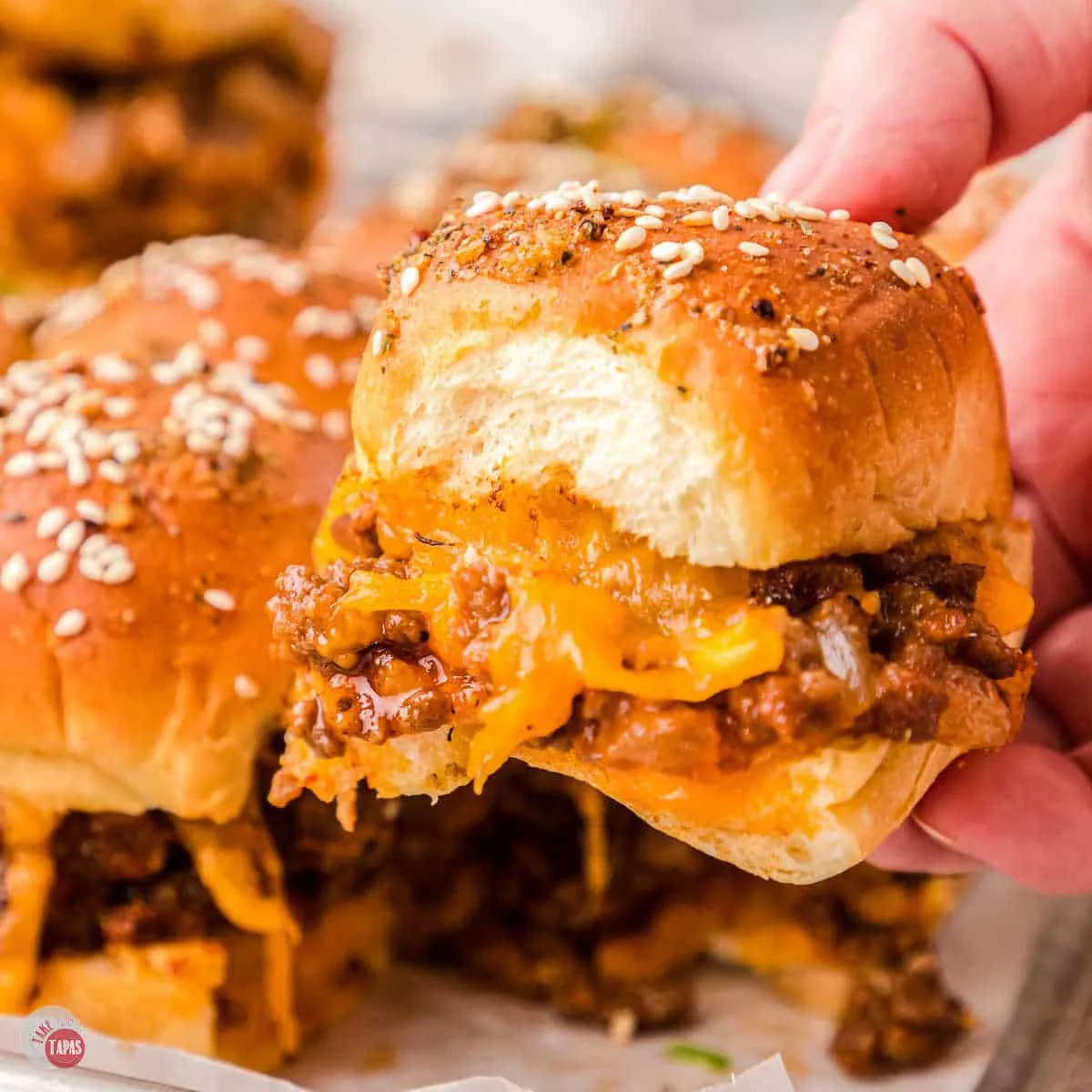 sloppy joe slider in a hand with bite missing