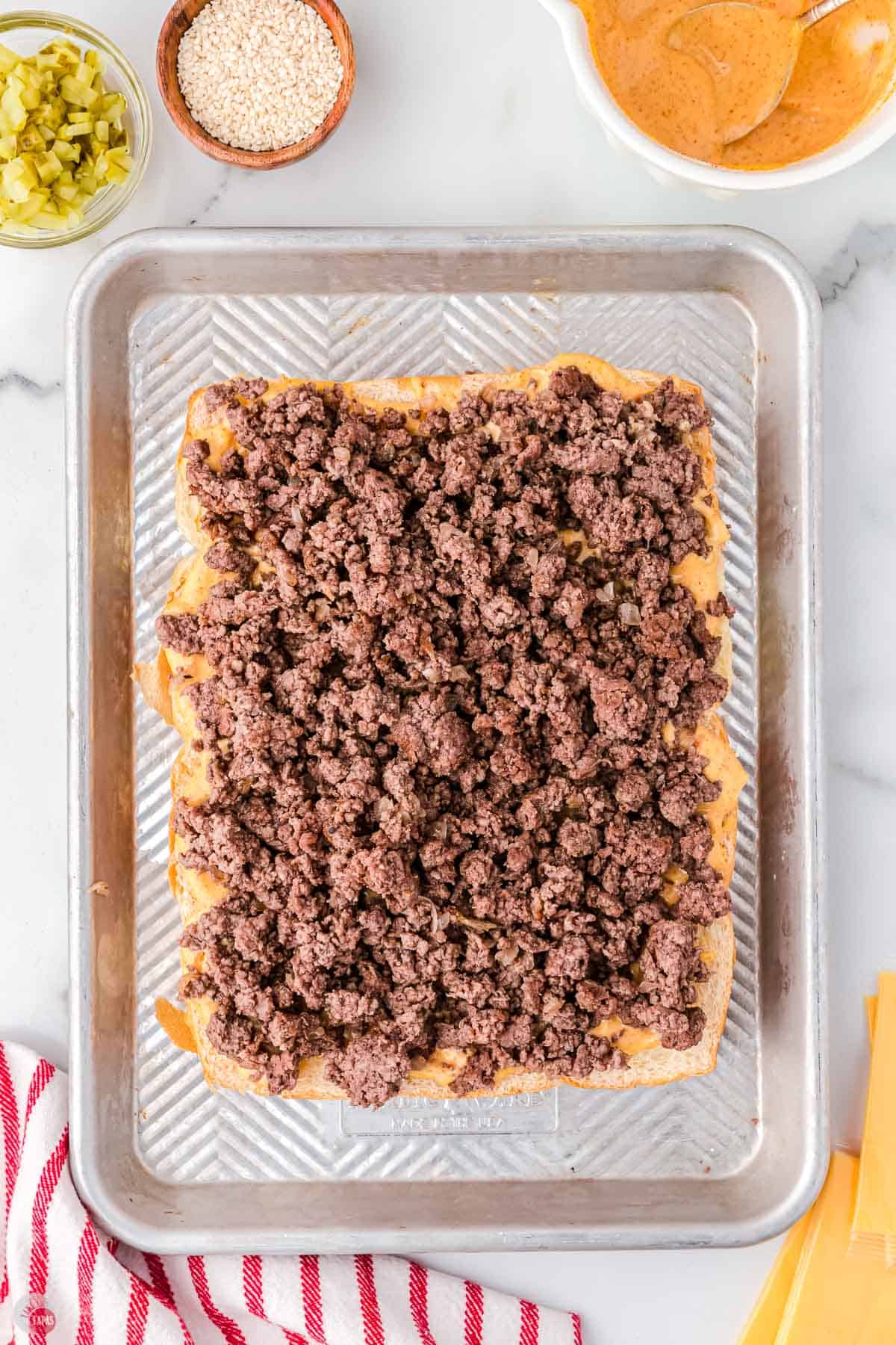 ground beef on buns in a baking sheet