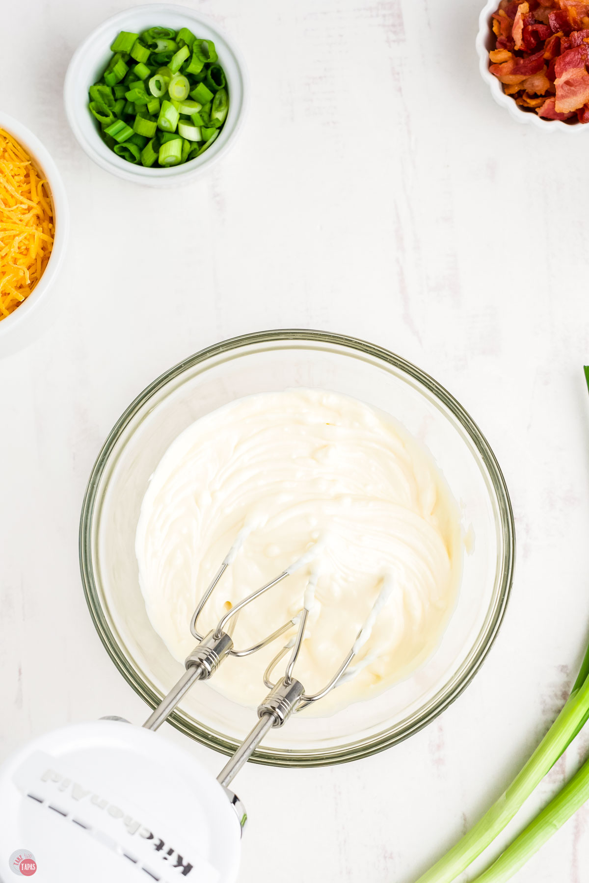 cream cheese and spices mixed in a bowl with beaters