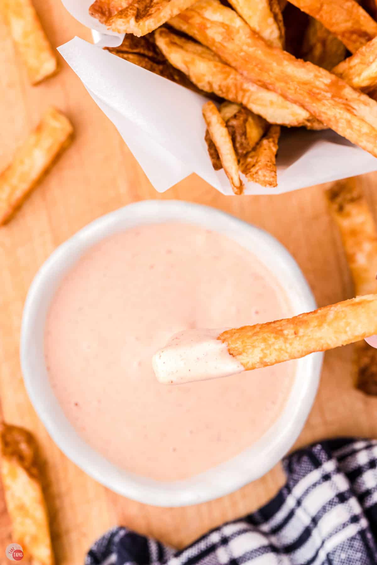 comeback sauce in a white bowl with a french fry dipping in