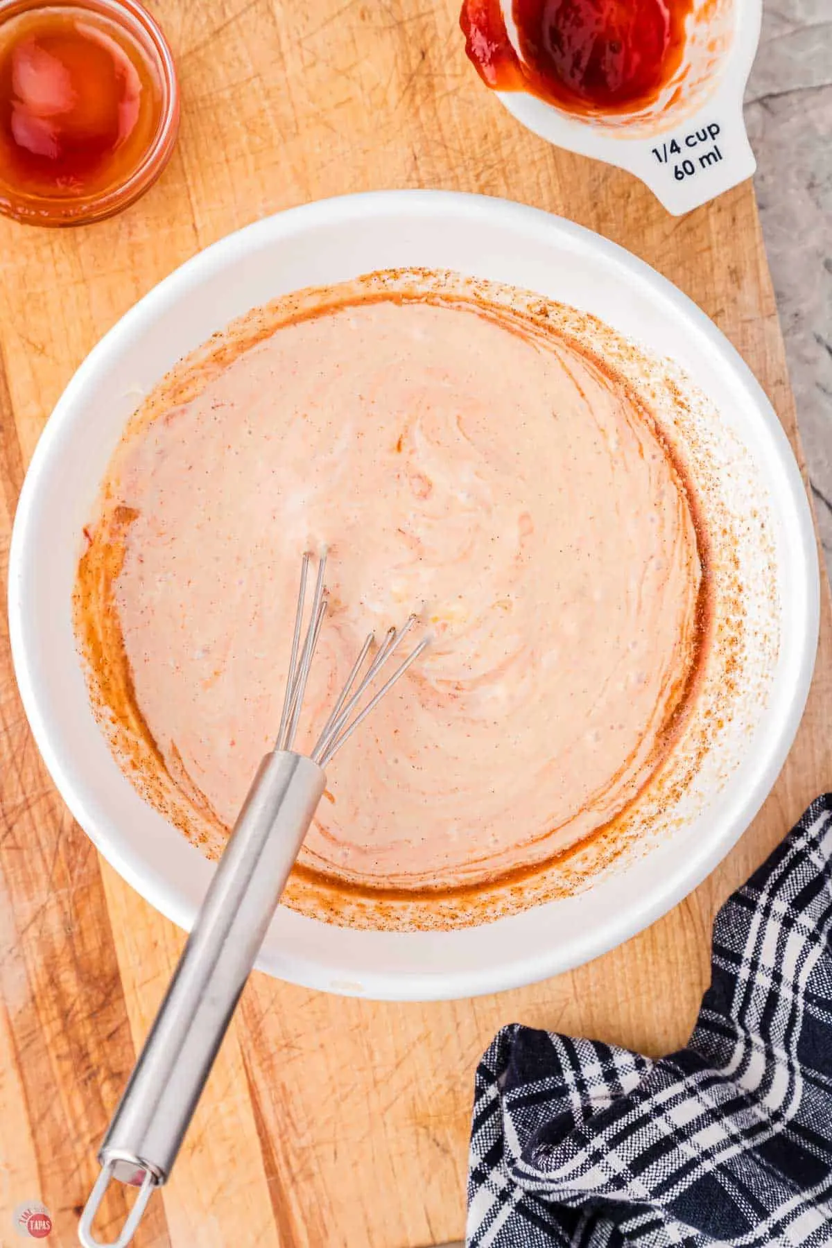 a tasty sauce in a white bowl with a whisk