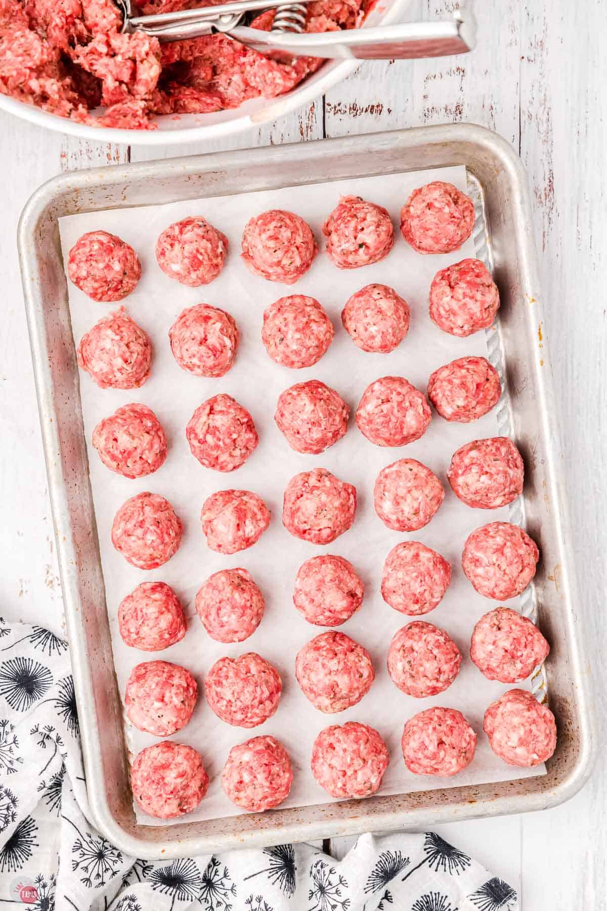 unbaked meatballs on a baking sheet